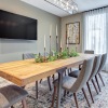 a dining room table with chairs and a tv above it